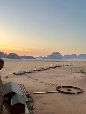 a row of domes in the desert at sunset at Wadi Rum Neom camp in Wadi Rum