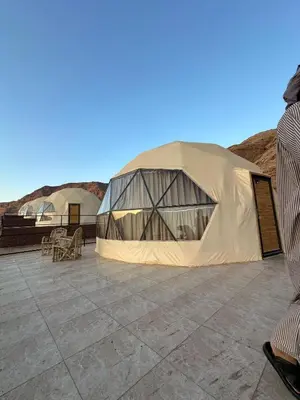 a large tent on a roof with mountains in the background at Wadi Rum Neom camp in Wadi Rum
