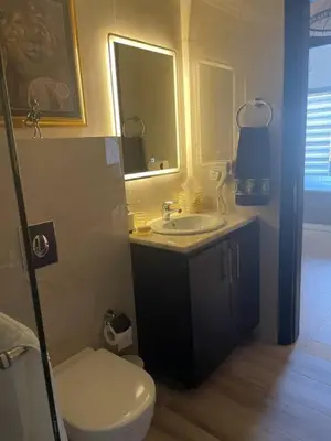 a bathroom with a sink and a toilet and a mirror at The F52 Luxury Residence Samarah Resort in Sowayma