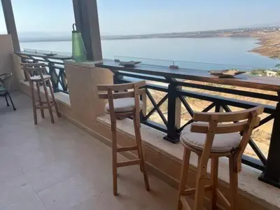 three chairs and a table on a balcony overlooking the ocean at The F52 Luxury Residence Samarah Resort in Sowayma