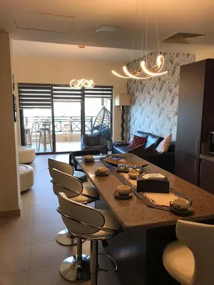 a living room with a large table and chairs at The F52 Luxury Residence Samarah Resort in Sowayma