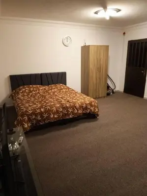 a bedroom with a bed and a wooden cabinet at Kamalia Studio in Şāfūţ