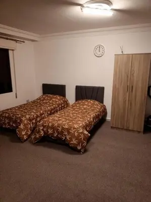 a bedroom with a bed and a clock on the wall at Kamalia Studio in Şāfūţ