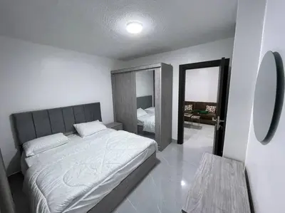 a bedroom with a large bed and a mirror at شقارى 12 in Ţāb Kirā‘
