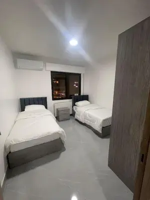 a bedroom with two beds and a window at شقارى 16 in Ţāb Kirā‘