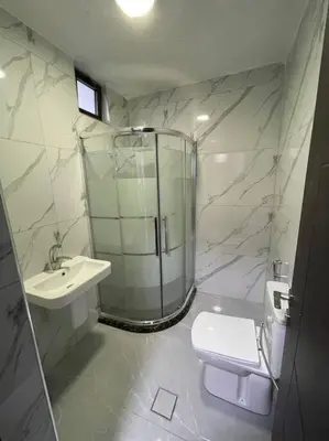 a bathroom with a shower and a toilet and a sink at شقارى 16 in Ţāb Kirā‘