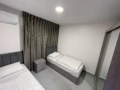 a small bedroom with two beds and a window at شقارى 16 in Ţāb Kirā‘