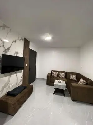 a living room with two couches and a flat screen tv at شقارى 5 in Ţāb Kirā‘