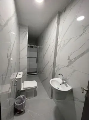 a white bathroom with a sink and a toilet at شقارى 5 in Ţāb Kirā‘