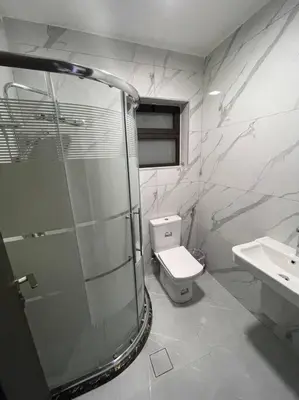 a bathroom with a shower and a toilet and a sink at شقارى 11 in Ţāb Kirā‘