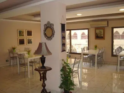 a dining room with tables and chairs and a mirror at New Rafi Hotel in Amman