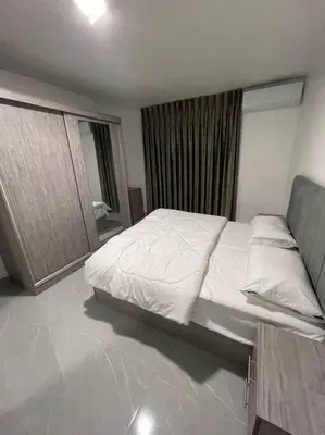 a bedroom with a white bed and a mirror at شقارى 14 in Ţāb Kirā‘
