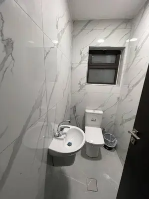 a white bathroom with a sink and a toilet at شقارى 14 in Ţāb Kirā‘