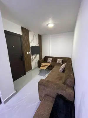 a living room with a couch and a flat screen tv at شقارى 15 in Ţāb Kirā‘