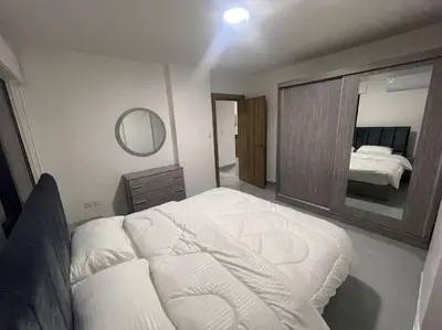 a bedroom with a bed and a large mirror at شقارى 15 in Ţāb Kirā‘
