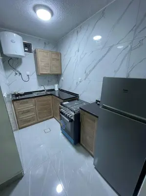 a small kitchen with a stove and a refrigerator at شقارى 15 in Ţāb Kirā‘