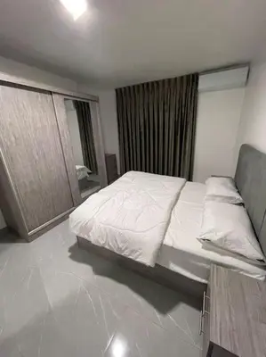 a bedroom with a white bed and a mirror at شقارى 10 in Ţāb Kirā‘