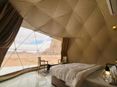 a bedroom with a tent with a view of the desert at RUM MAGIC SANDS BuBBLES CAMP in Wadi Rum