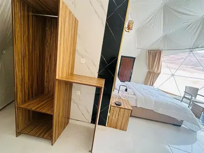 a bedroom with a bed and a mirror at RUM MAGIC SANDS BuBBLES CAMP in Wadi Rum