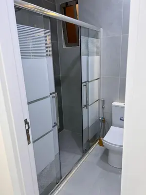 a bathroom with a shower and a toilet at شقة مفروشة و جديدة مع كراج للسيارة في ارقى مناطق اربد in Irbid