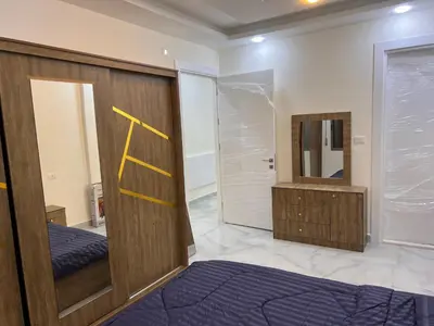 a room with a wooden door and a mirror at شقة مفروشة و جديدة مع كراج للسيارة في ارقى مناطق اربد in Irbid