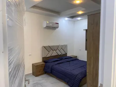 a bedroom with a bed with a blue comforter at شقة مفروشة و جديدة مع كراج للسيارة في ارقى مناطق اربد in Irbid