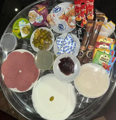 a glass table topped with different types of food at City centre Apartment in Petra