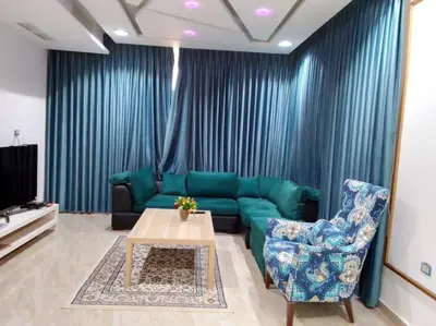 a living room with a green couch and a table at Vienna Villa for you in Al Qasţal