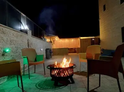 a fire pit in the middle of a patio at night at Vienna Villa for you in Al Qasţal