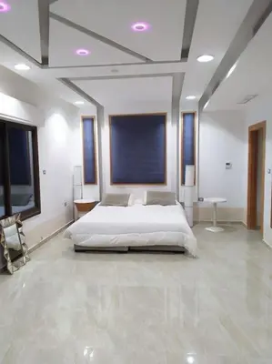 a large white bedroom with a bed in a room at Vienna Villa for you in Al Qasţal