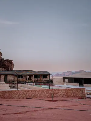 a building with a pool in front of it at Rum Rosella camp in Wadi Rum