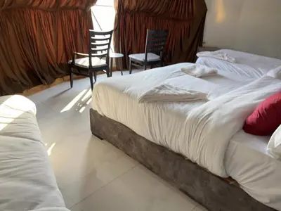 a bedroom with two beds and two chairs at Rum Rosella camp in Wadi Rum