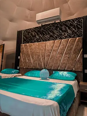 a bedroom with a bed with blue pillows at Rum Ronaldo camp in Wadi Rum