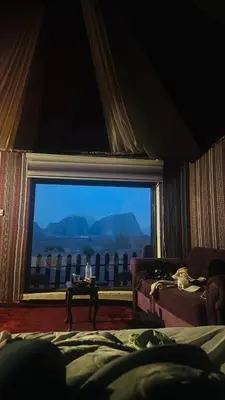 a bedroom with a large window with a view at Rum Ronaldo camp in Wadi Rum