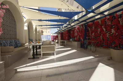 a lobby with tables and chairs and a wall of flowers at G Hotel Amman in Amman