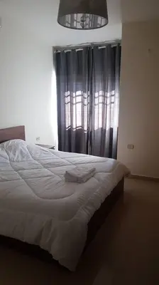a bedroom with a white bed with a window at Apartment in Amman Khalda in Amman