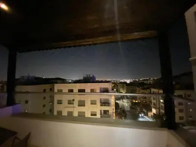 a view of a city at night from a window at Apartment in Amman Khalda in Amman