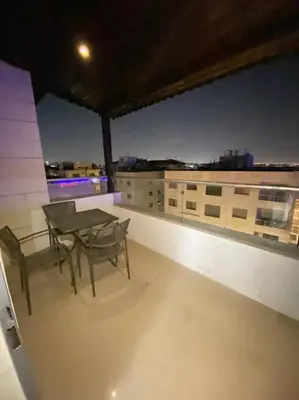 a balcony with a table and chairs on a building at Apartment in Amman Khalda in Amman