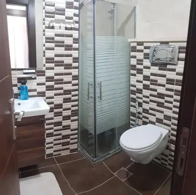 a bathroom with a toilet and a glass shower at Apartment in Amman Abdoun area in Amman