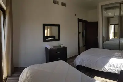 a hotel room with two beds and a mirror at Apartment in Amman Abdoun area in Amman