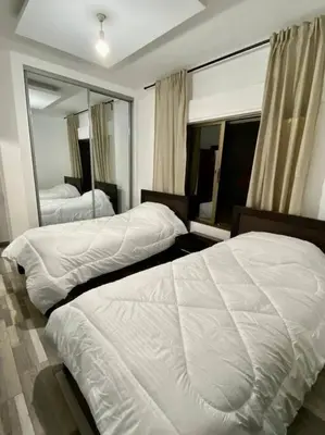 a bedroom with two beds and a large mirror at Apartment in Amman Abdoun area in Amman