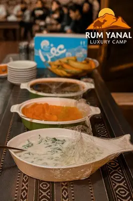 a buffet with bowls of food on a table at RUM YANAL lUXURY CAMP in Wadi Rum