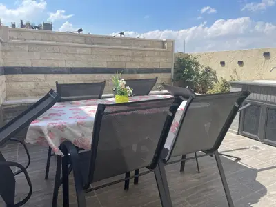 a table and two chairs on a patio with a table andatoes at Modern Rooftop apartment in Amman