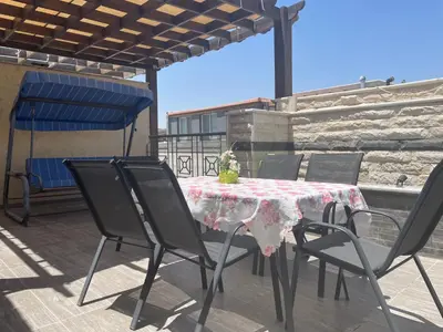 a table and chairs sitting on a patio at Modern Rooftop apartment in Amman