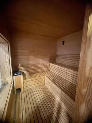 an empty wooden sauna with a chair in it at Modern Rooftop apartment in Amman