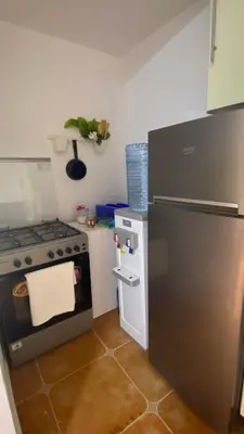 a kitchen with a stainless steel refrigerator and a stove at SeaStar Sea View apartment 10 minutes away from beach in Sowayma