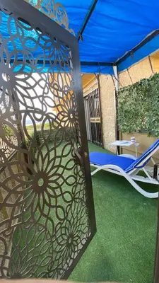 a iron gate with a chair and a table at SeaStar Sea View apartment 10 minutes away from beach in Sowayma