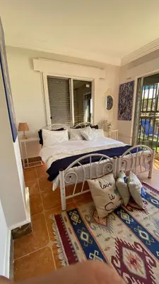 a bedroom with a white bed and a rug at SeaStar Sea View apartment 10 minutes away from beach in Sowayma