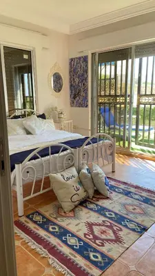a bedroom with a bed with pillows on a rug at SeaStar Sea View apartment 10 minutes away from beach in Sowayma