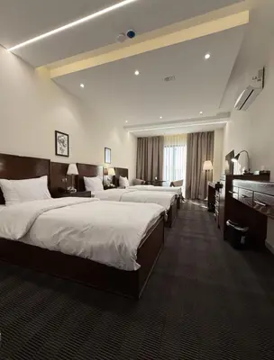 a hotel room with three beds and a piano at North paradise hotel in Irbid